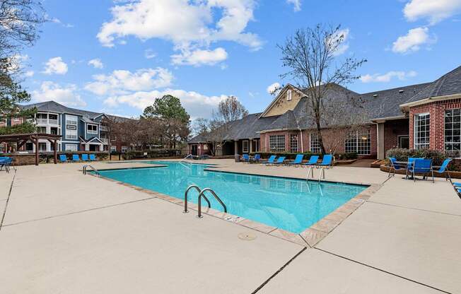 A large swimming pool surrounded by blue lounge chairs.