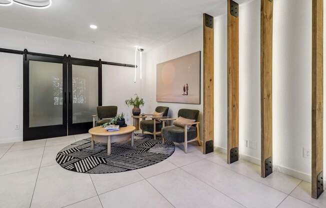 A modern living room with a glass door, a wooden table, and a rug.