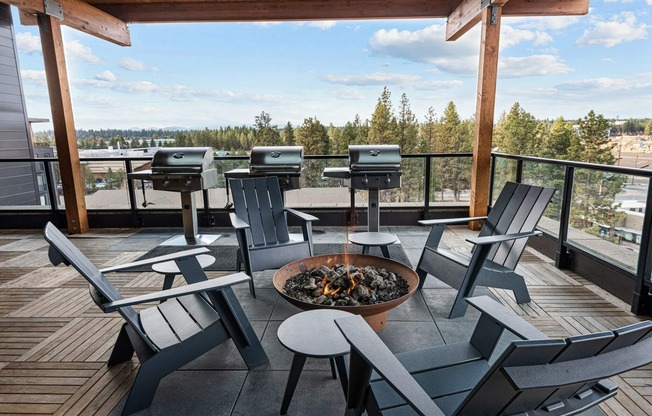 rooftop deck with wooden lounge chairs around fire pit