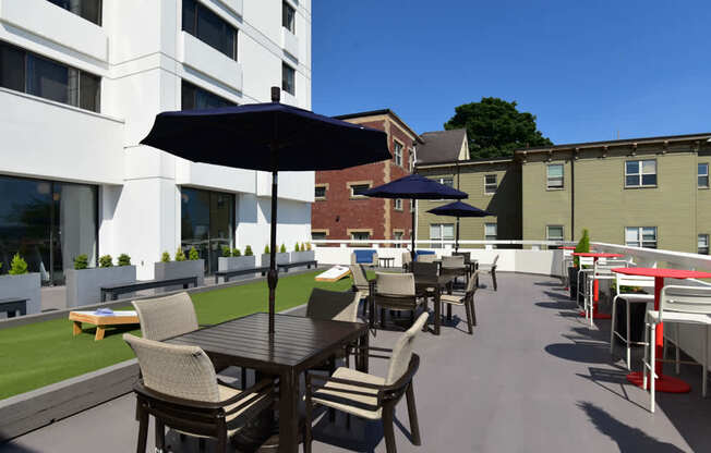 A patio with a table and chairs is surrounded by buildings.