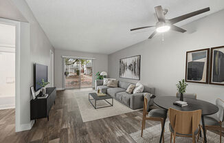 Model Living Room with Wood-Style Flooring and Patio Accessibility at Crystal Creek Apartments located in Phoenix, AZ.