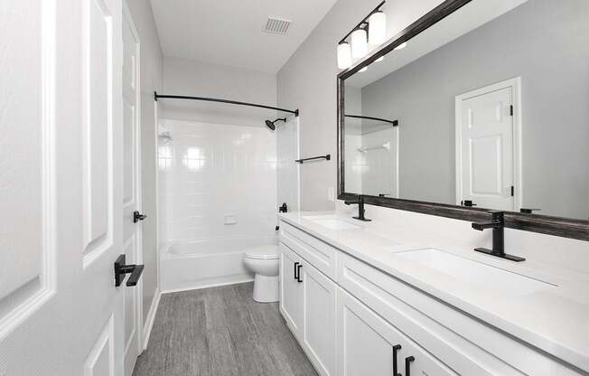 Bathrooms with double vanity sinks, garden soaking tubs and curved shower rods