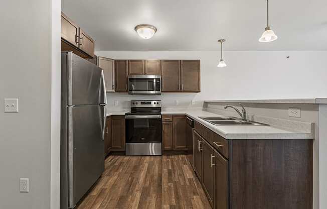 an empty kitchen with stainless steel appliances and wooden cabinets