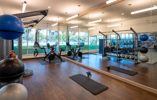 a gym with weights and other exercise equipment and a view of a tennis court at Sinclaire on Seminary, Alexandria, VA 22311
