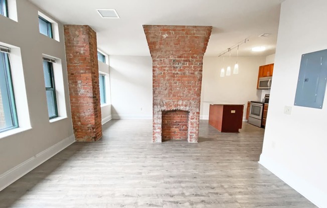 a living room with a fireplace and a kitchen in the background