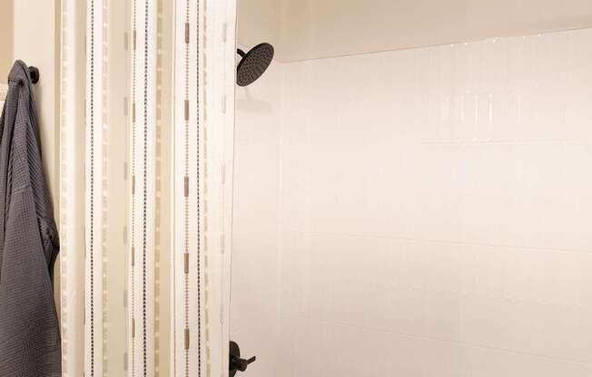 A shower curtain with a grey towel hanging on a towel rack.