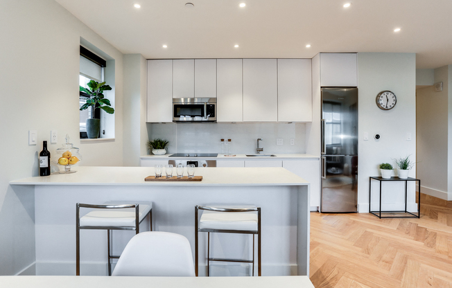 Custom kitchen with quartz countertops, hardwood floors and Bosch appliances and an island