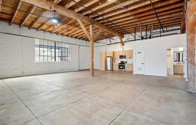 A large, empty room with a high ceiling and wooden beams.