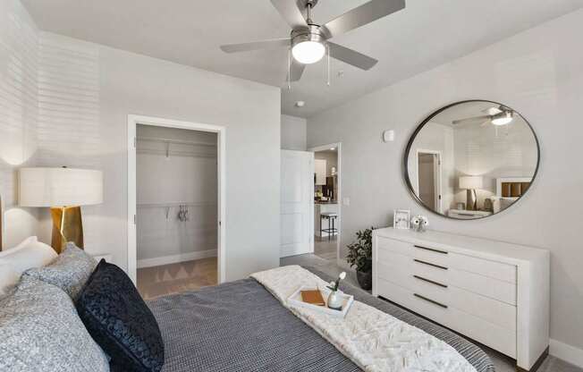 A bedroom with a bed, dresser, and mirror.
