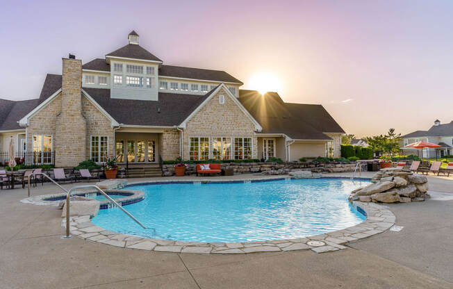 a large swimming pool with a house in the background