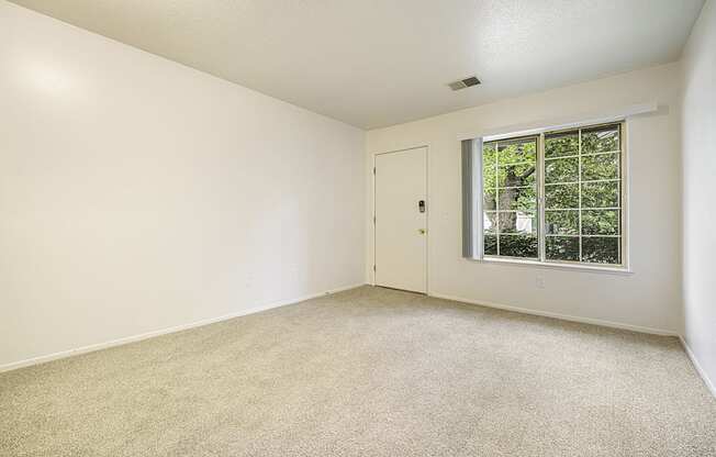 Main floor living with a large window at Newport Village Apartments, Portage, MI