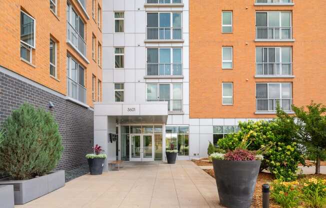 the entrance to an apartment building with a walkway and plants