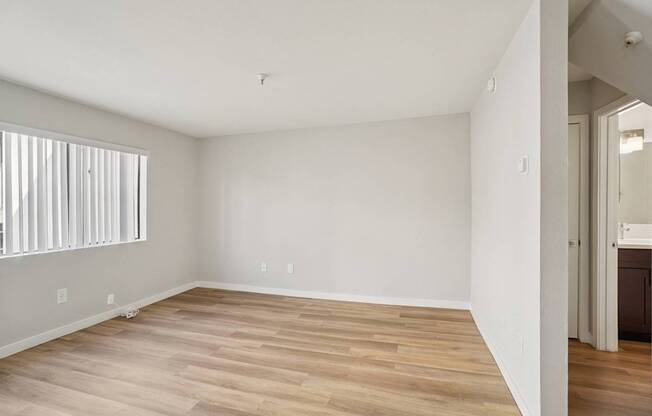 A room with wooden flooring and white walls.