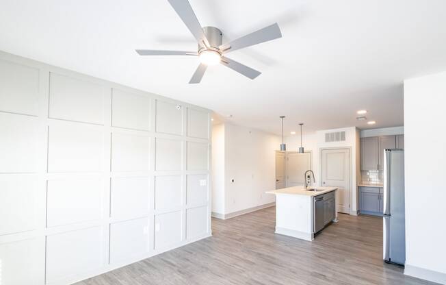 a white kitchen with a ceiling fan and a kitchen island