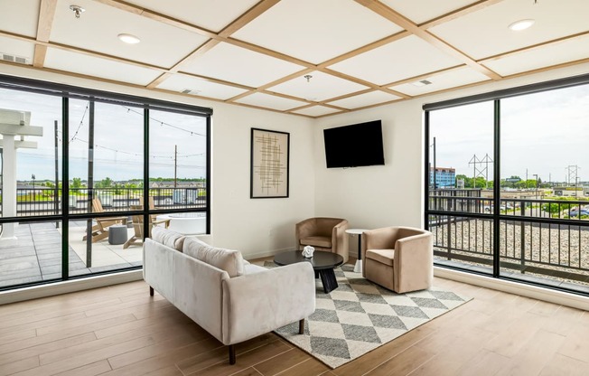 a living room with couches and chairs and large windows at The Standard on 32nd, West Fargo, ND