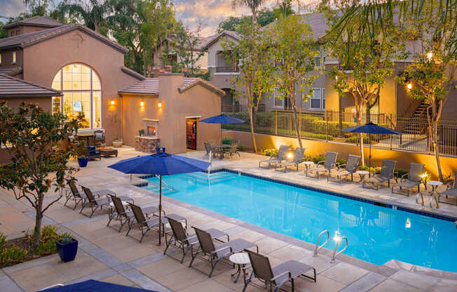 A pool surrounded by chairs and umbrellas.