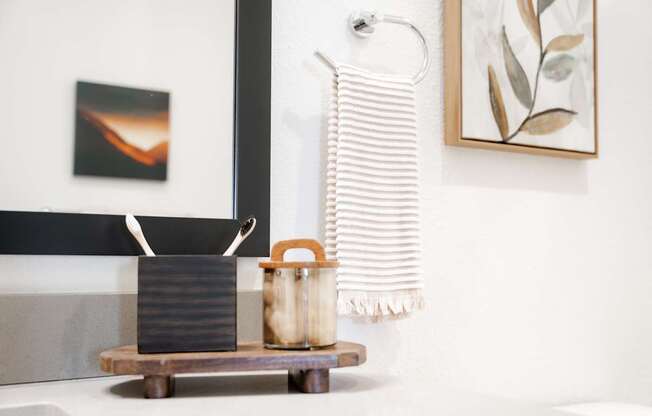 A bathroom with a white sink and a striped towel hanging on the wall.