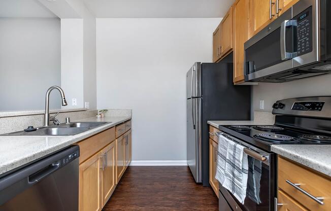 a large kitchen with stainless steel appliances and wooden cabinets