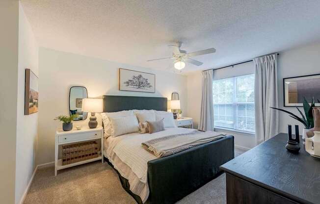 A bedroom with a large bed and a ceiling fan.