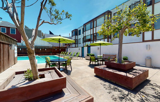 a patio with a pool and chairs and umbrellas