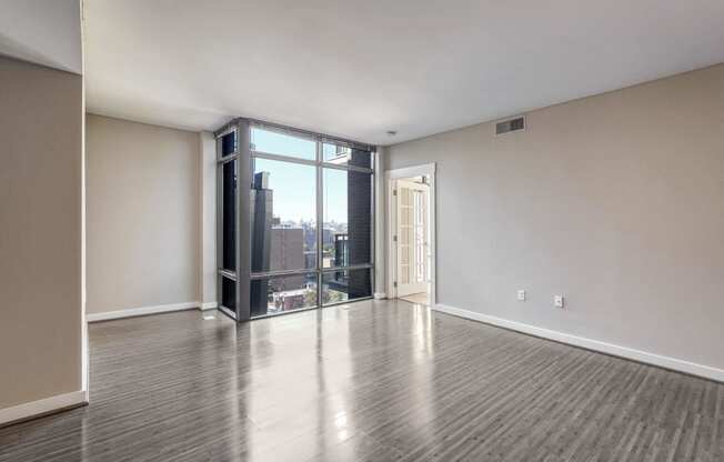 an empty living room with white walls and a large window