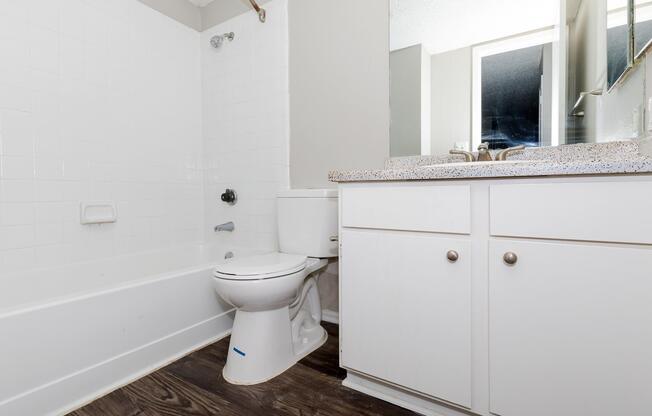 vacant bathroom with white cabinets