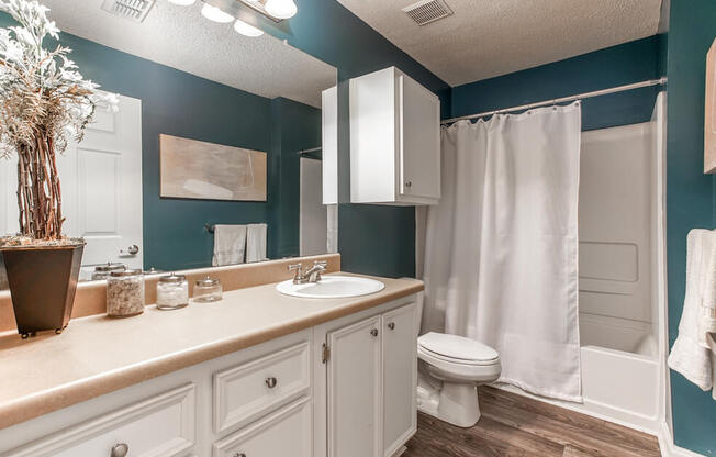 A bathroom with a white toilet and a white shower curtain.