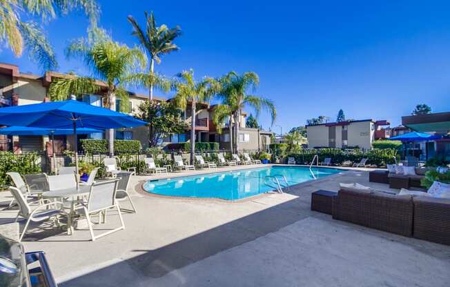 a swimming pool with lounge chairs and umbrellas