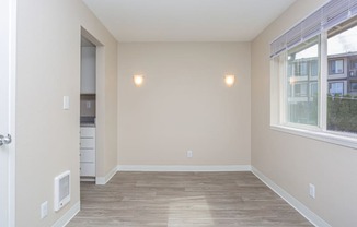 a bedroom with hardwood flooring and a large window