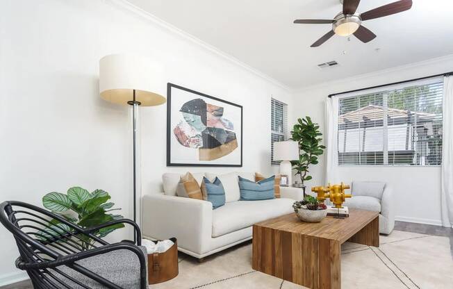 Living Room with Ceiling Fan and Multiple Windows