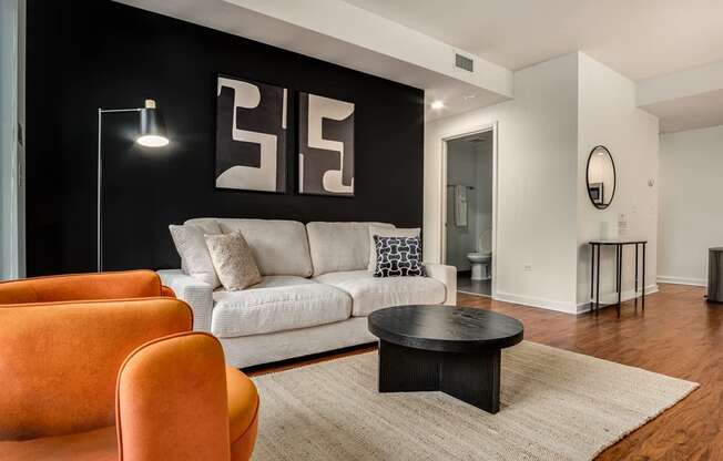 A living room with a white couch, a black coffee table, and a floor lamp.