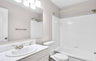 A white bathroom with a sink, toilet, and bathtub.