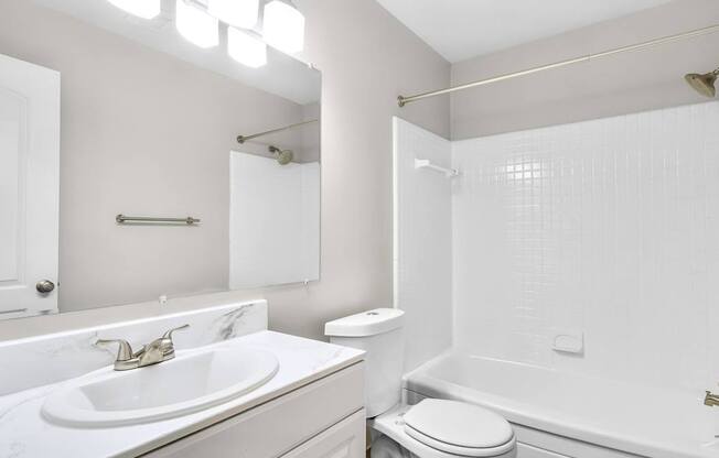 A white bathroom with a sink, toilet, and bathtub.