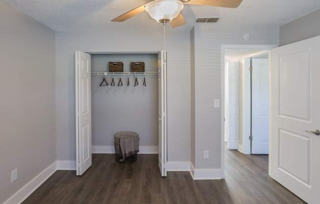 a hallway with a closet and a ceiling fan