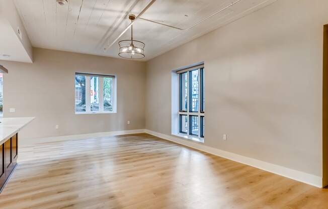 an empty living room with wood floors and windows