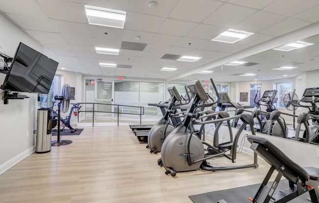 a gym with rows of exercise bikes on a wooden floor