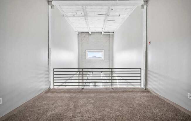 A white room with a carpeted floor and a metal gate.