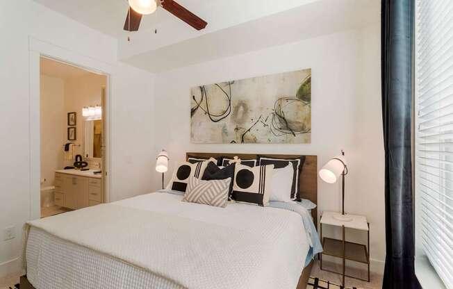 A bedroom with a large bed and a ceiling fan.