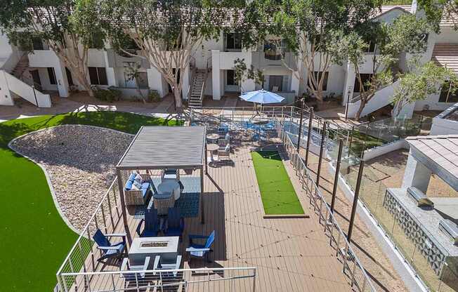 A patio with a table and chairs is surrounded by a metal fence.