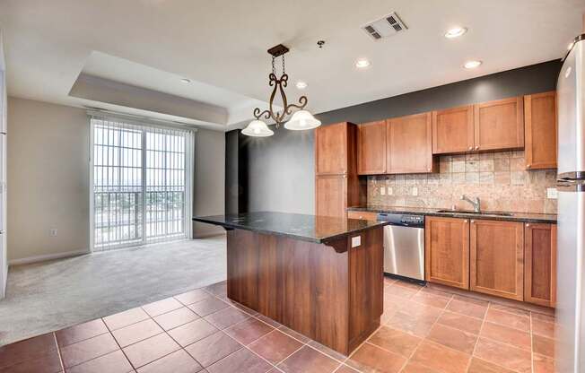 A kitchen with a black counter top and wooden cabinets.
