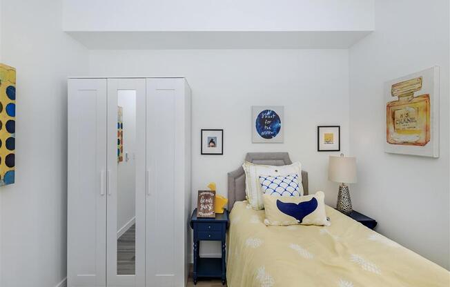 a bedroom with white walls and a yellow bedspread at Jefferson Yards, Tacoma