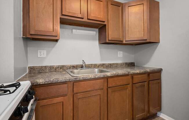 A kitchen with wooden cabinets and a white stove.
