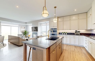 a large kitchen with an island and a living room