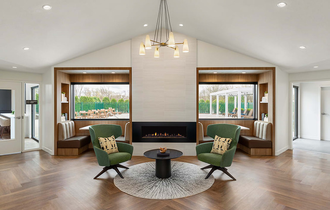 A modern living room with a fireplace and two green chairs.