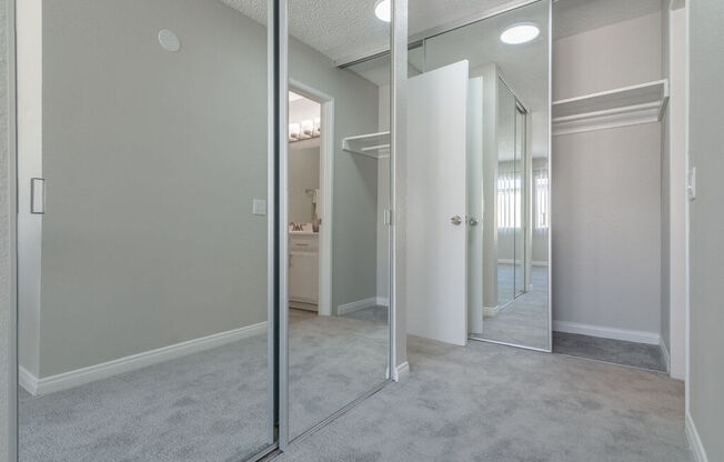 an empty bedroom with mirrored closet doors and a bathroom at Citra Apartments LLC, California, 92107