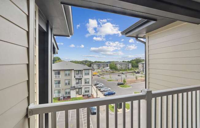 A balcony view of a residential area with cars and buildings.