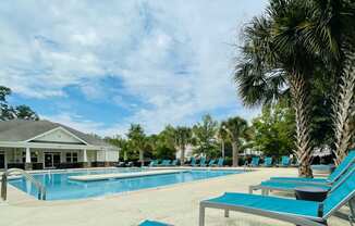 Beautiful pool with loungers at Oasis at Cedar Branch in Wilmington, NC