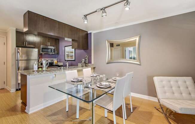 a kitchen and dining room with a glass table and chairs