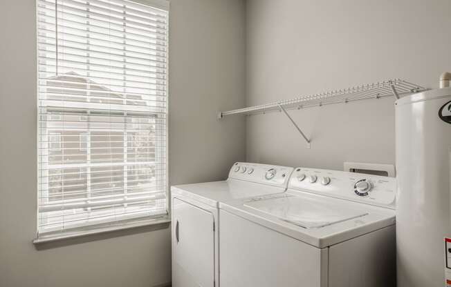 a white washer and dryer in a room with a window and a white