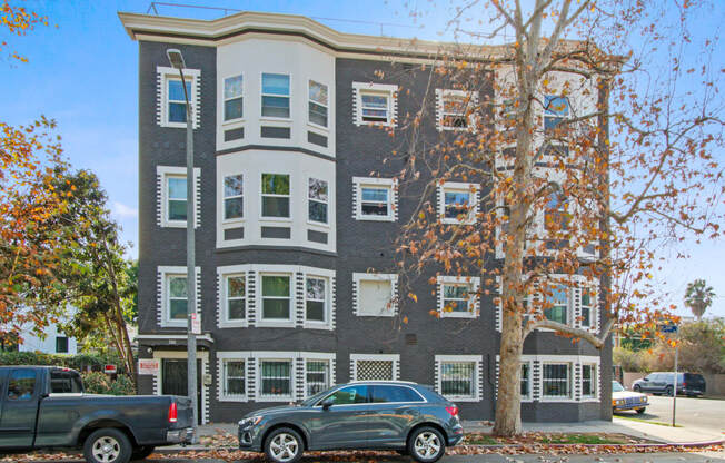 an apartment building with cars parked in front of it